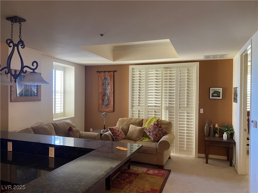 2405 West Serene Avenue, Unit 827 Las Vegas, NV 89123 - Photo 38 of 48 Living area with a tray ceiling and light colored carpet