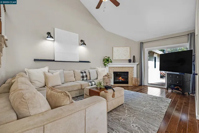 a living room with furniture a flat screen tv and a fireplace