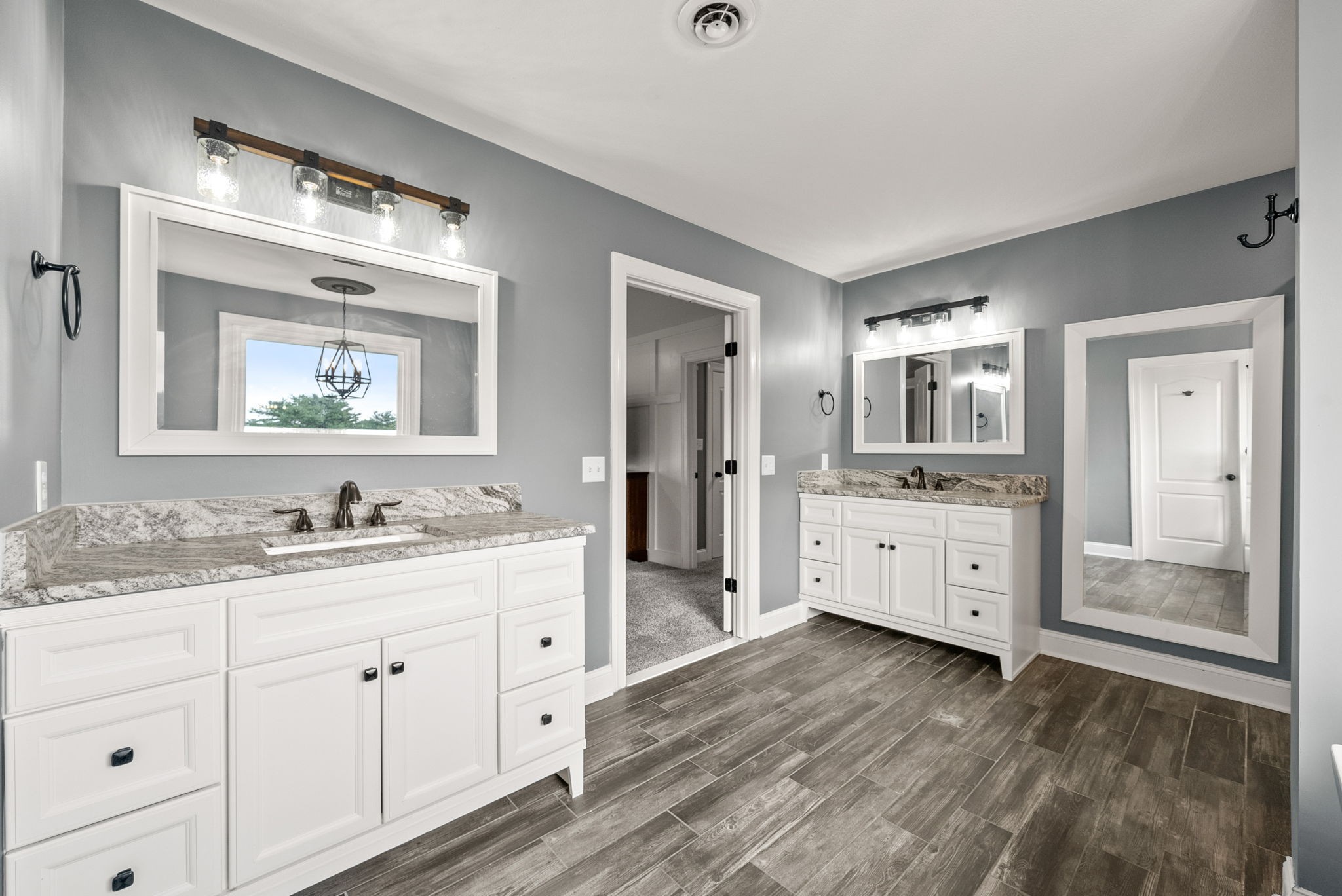 4921 Sango Road Clarksville, TN 37043 - Photo 28 of 52 a spacious bathroom with a double vanity sink a mirror a bathtub and window