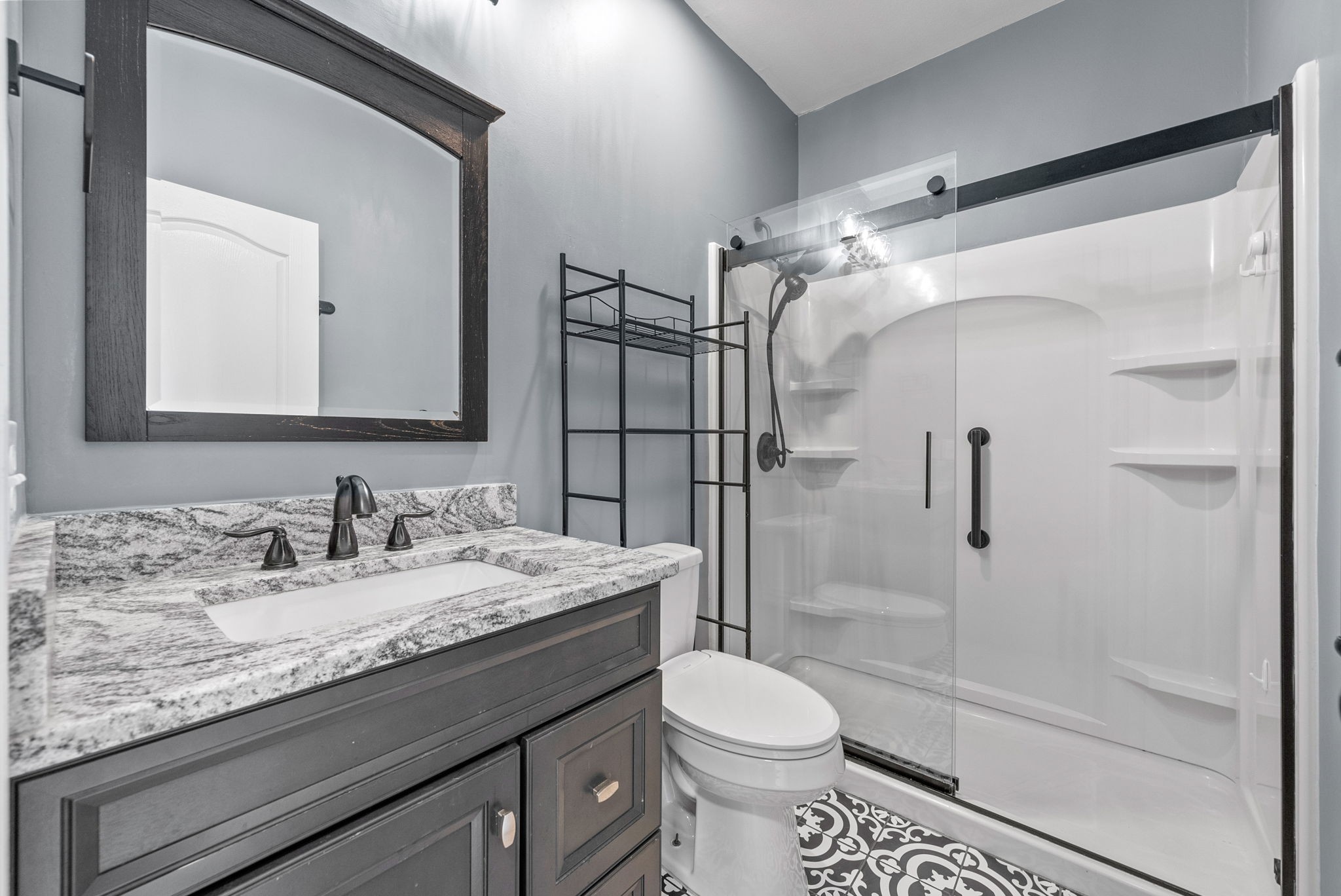 4921 Sango Road Clarksville, TN 37043 - Photo 34 of 52 a bathroom with a granite countertop sink toilet mirror and shower