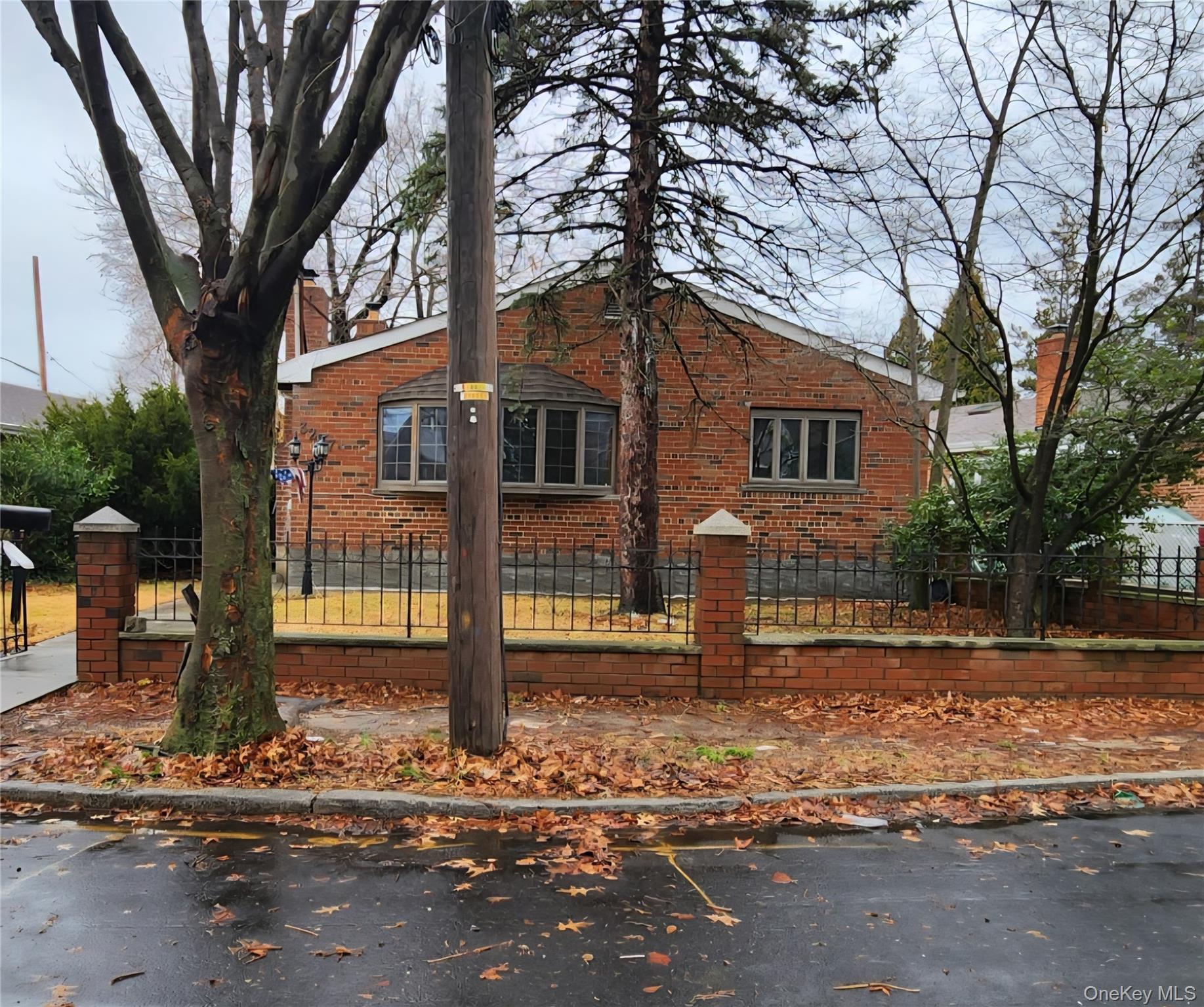 3237 Rawlins Avenue Bronx, NY 10465 - Photo 1 of 1 View of side of property with a fenced front yard, brick siding, and a chimney
