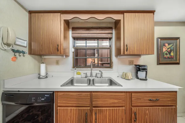 a kitchen with a sink cabinets and a window