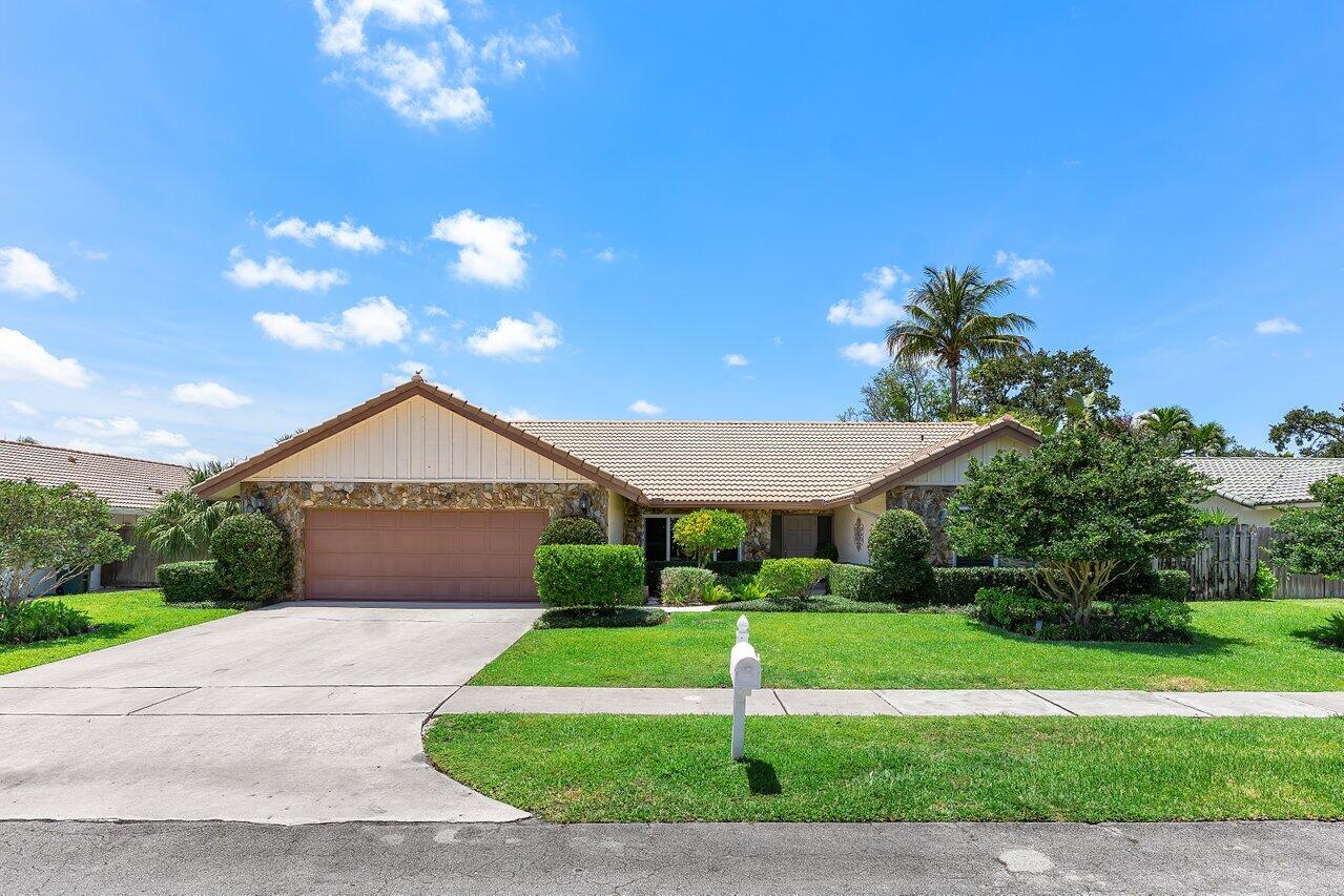 1935 Southwest 7th Court Boca Raton, FL 33486 - Photo 1 of 42 a front view of a house with a yard