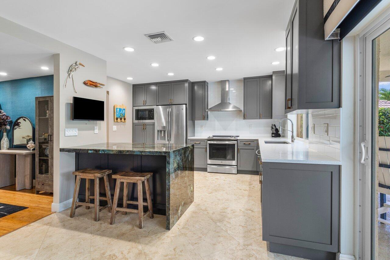 1935 Southwest 7th Court Boca Raton, FL 33486 - Photo 8 of 42 a large kitchen with stainless steel appliances granite countertop a stove a sink and a microwave