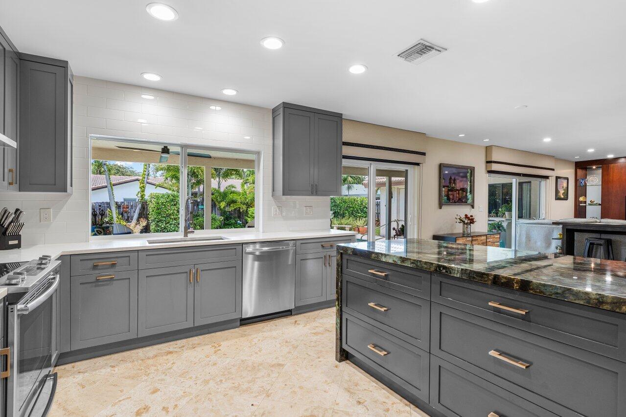 1935 Southwest 7th Court Boca Raton, FL 33486 - Photo 9 of 42 a large kitchen with kitchen island granite countertop a large window and white cabinets