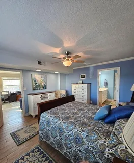 a bedroom with a large bed a chandelier and dresser