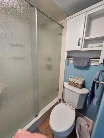 a white toilet sitting next to a shower