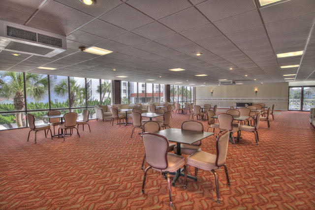 909 Santa Rosa Boulevard, Unit 229 Fort Walton Beach, FL 32548 - Photo 30 of 36 a room with lots of tables a large window and chairs