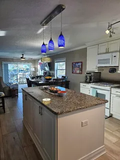 a kitchen with stainless steel appliances granite countertop a sink dishwasher and white cabinets with wooden floor