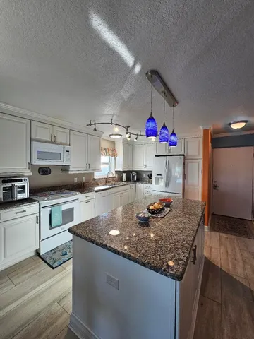 a kitchen with stainless steel appliances granite countertop a sink dishwasher and cabinets with wooden floor