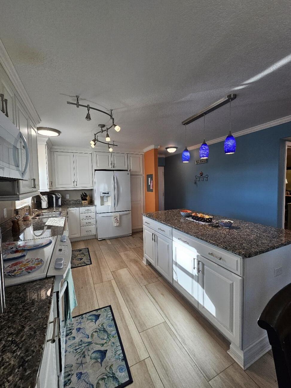 909 Santa Rosa Boulevard, Unit 229 Fort Walton Beach, FL 32548 - Photo 5 of 36 a large kitchen with granite countertop a lot of cabinets a sink and a stove