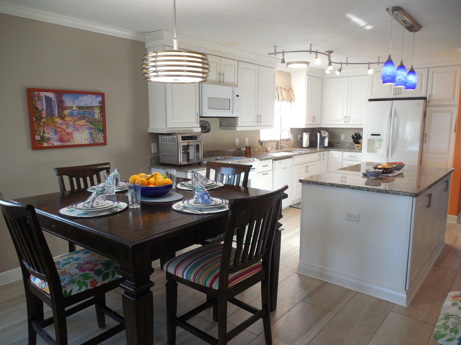 909 Santa Rosa Boulevard, Unit 229 Fort Walton Beach, FL 32548 - Photo 8 of 36 a kitchen with stainless steel appliances granite countertop a dining table chairs and a refrigerator
