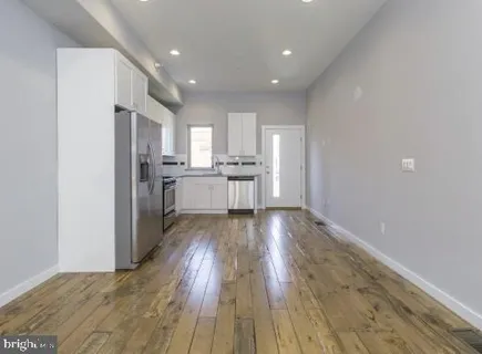 a view of kitchen with wooden floor electronic appliances and window