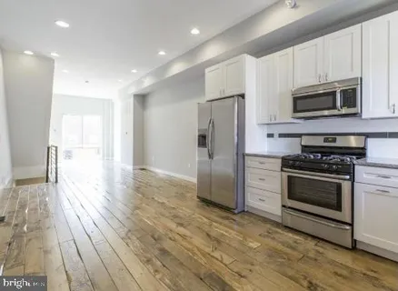 a kitchen with stainless steel appliances granite countertop a refrigerator microwave and stove top oven