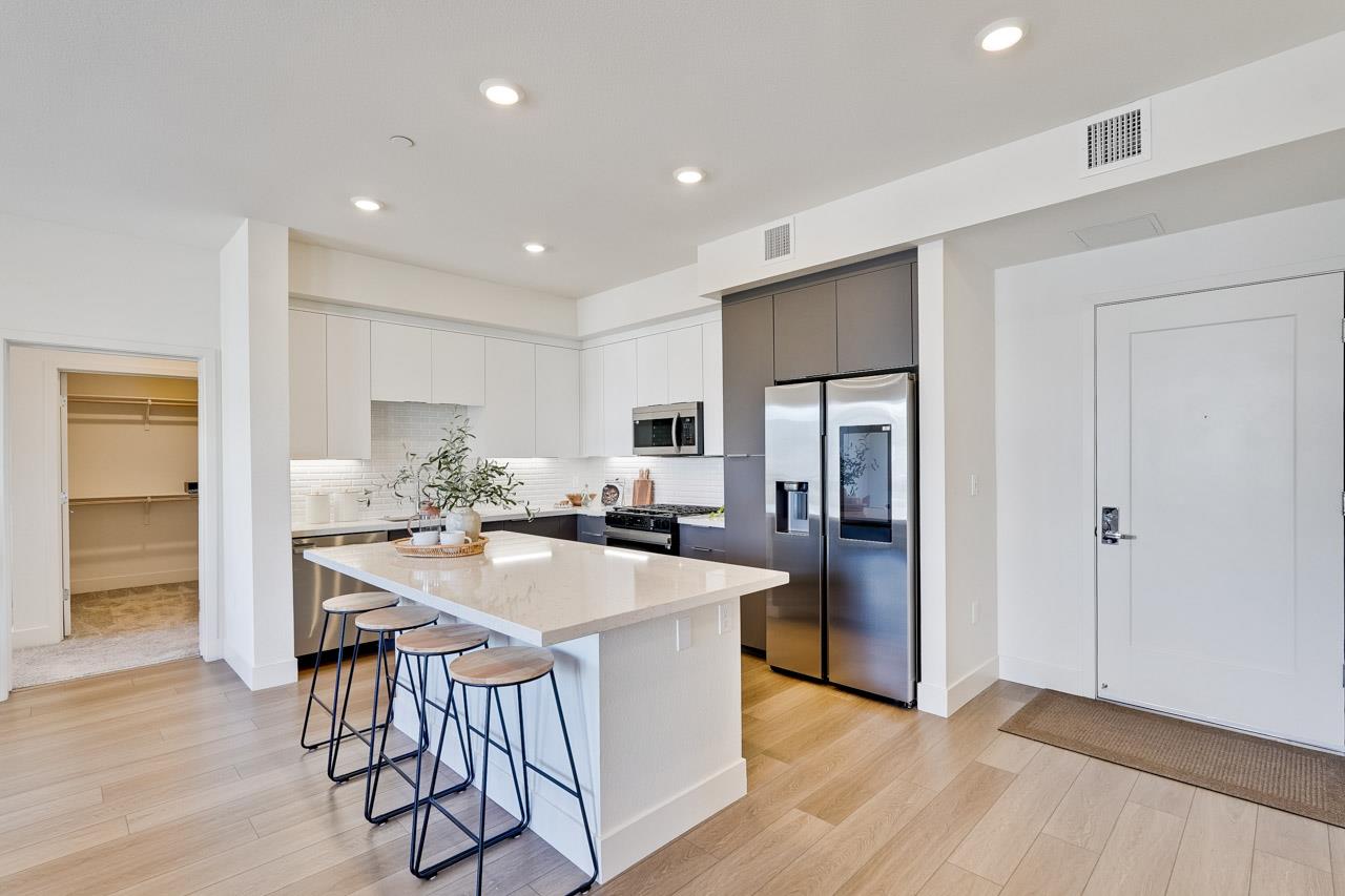 3698 Vision Common, Unit 221 Fremont, CA 94538 - Photo 12 of 62 a kitchen with a table chairs refrigerator and cabinets