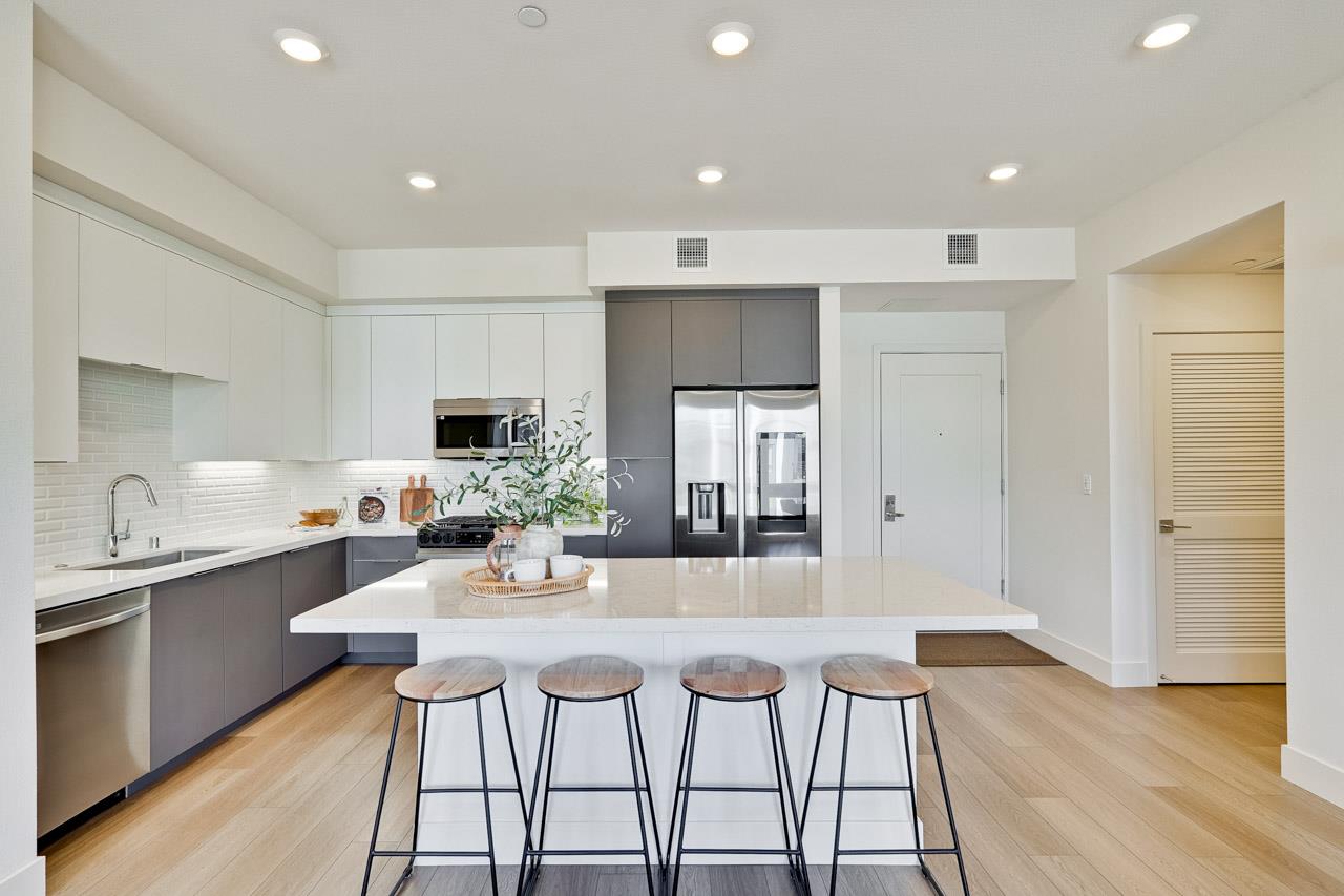 3698 Vision Common, Unit 221 Fremont, CA 94538 - Photo 13 of 62 a kitchen with stainless steel appliances granite countertop a stove top oven a sink dishwasher and a refrigerator with wooden floor
