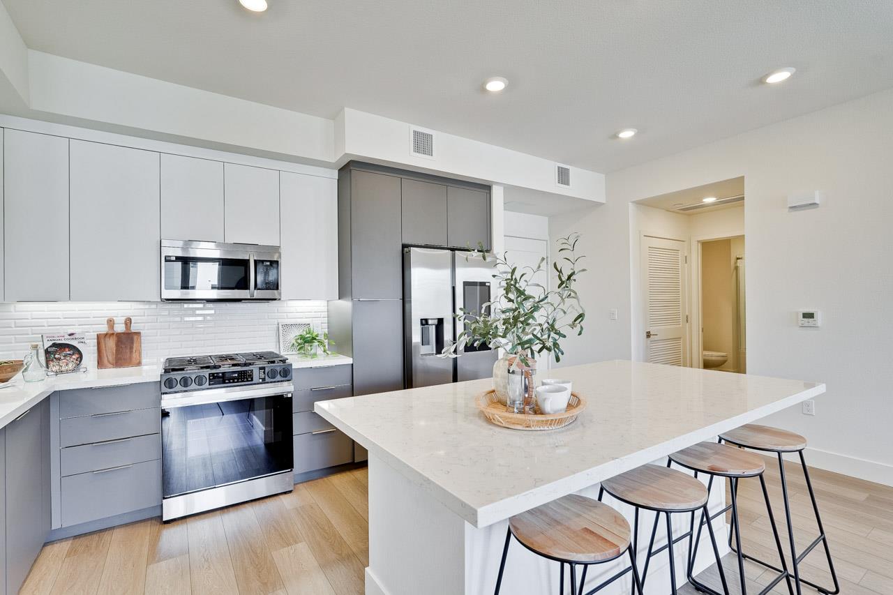 3698 Vision Common, Unit 221 Fremont, CA 94538 - Photo 14 of 62 a kitchen with stainless steel appliances a dining table chairs stove and refrigerator