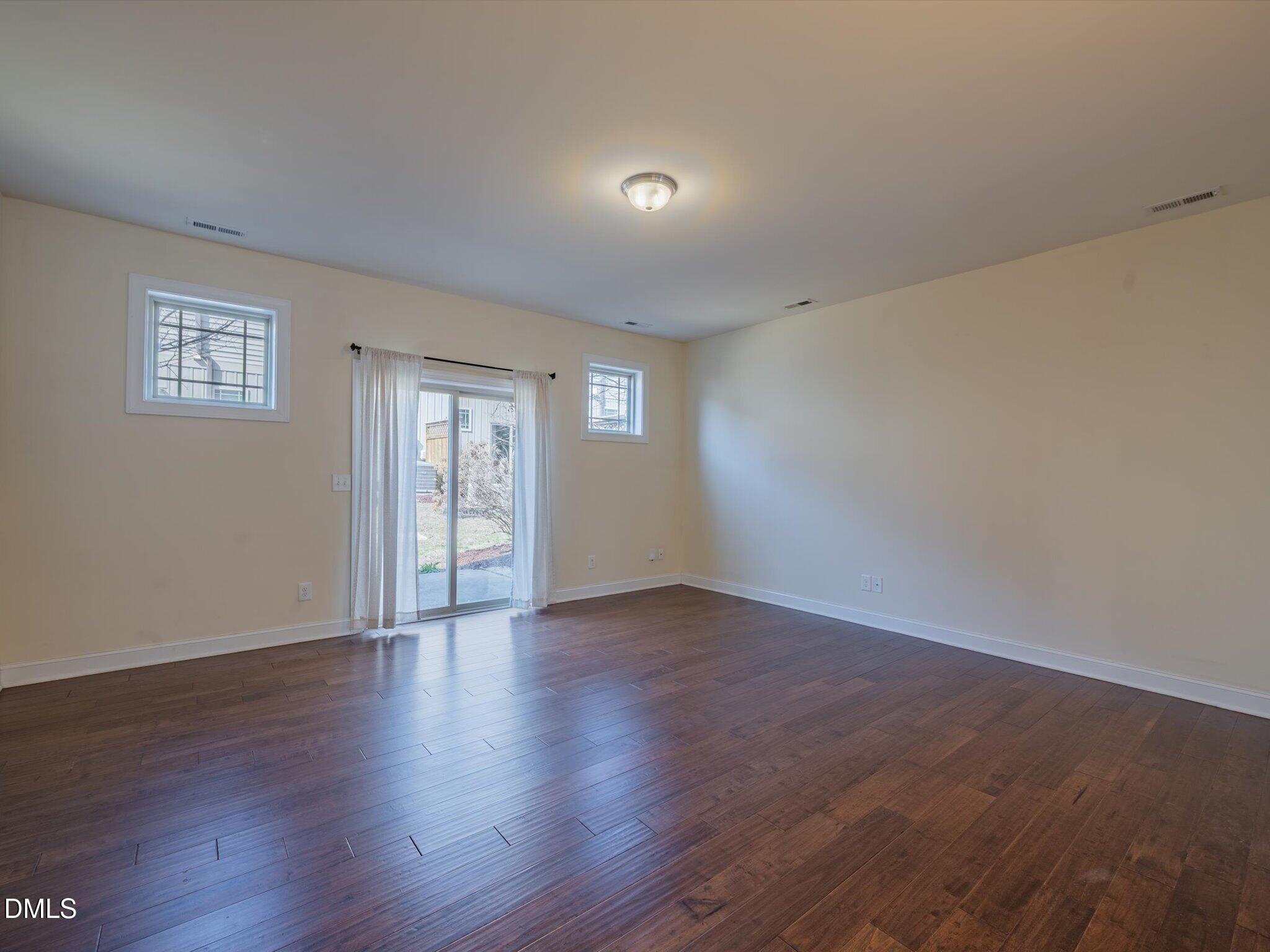 2808 Piedmont River Way Raleigh, NC 27606 - Photo 13 of 28 a view of an empty room with wooden floor and a window