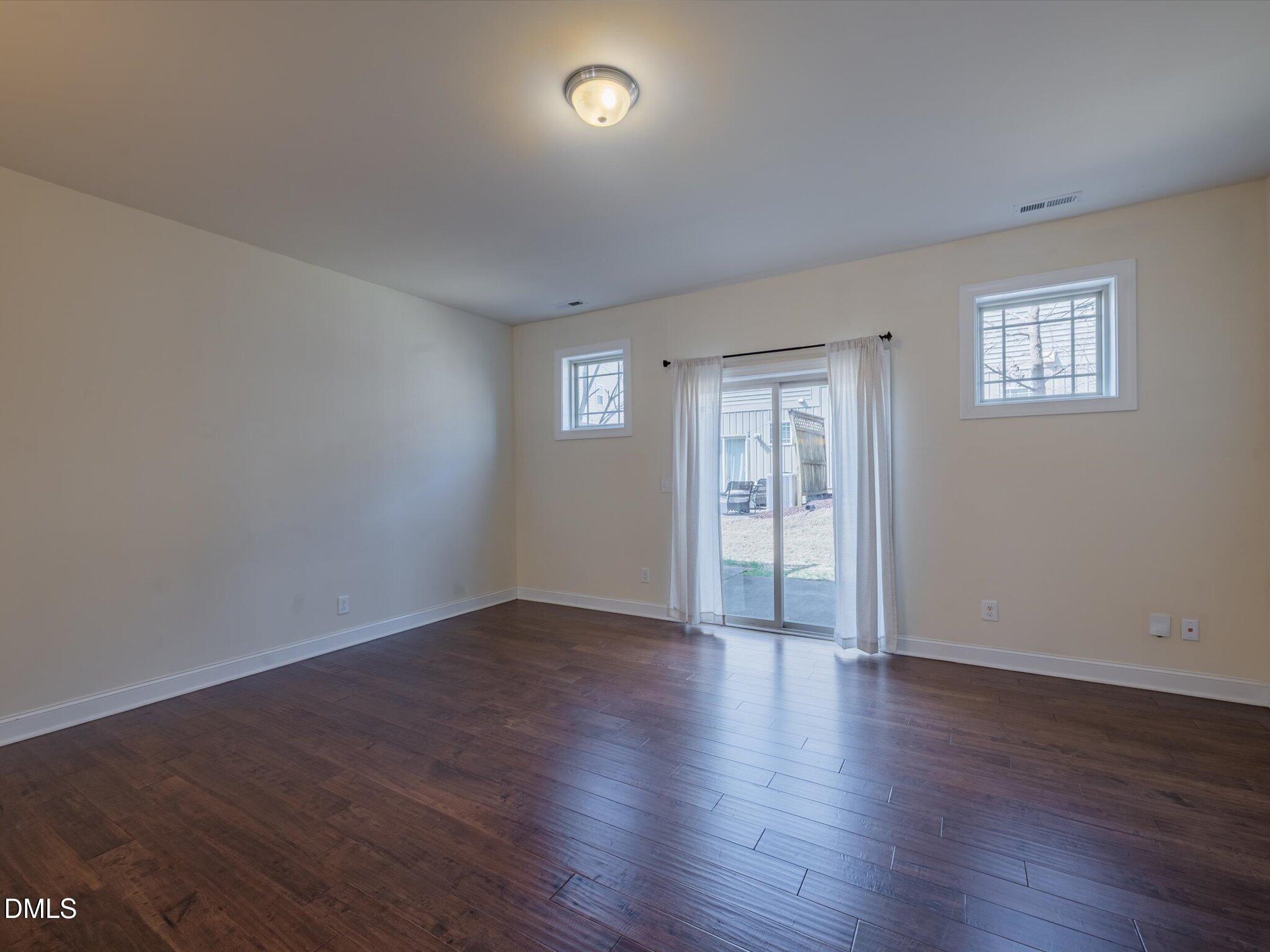 2808 Piedmont River Way Raleigh, NC 27606 - Photo 14 of 28 a view of an empty room with wooden floor and a window