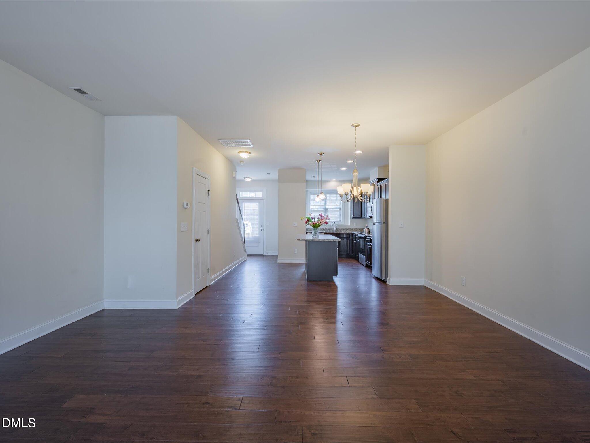 2808 Piedmont River Way Raleigh, NC 27606 - Photo 15 of 28 a view of a big room with wooden floor and a kitchen