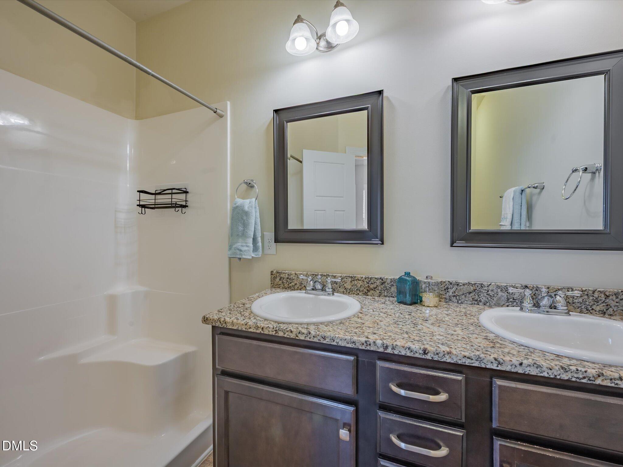 2808 Piedmont River Way Raleigh, NC 27606 - Photo 22 of 28 a bathroom with a granite countertop tub sink and mirror