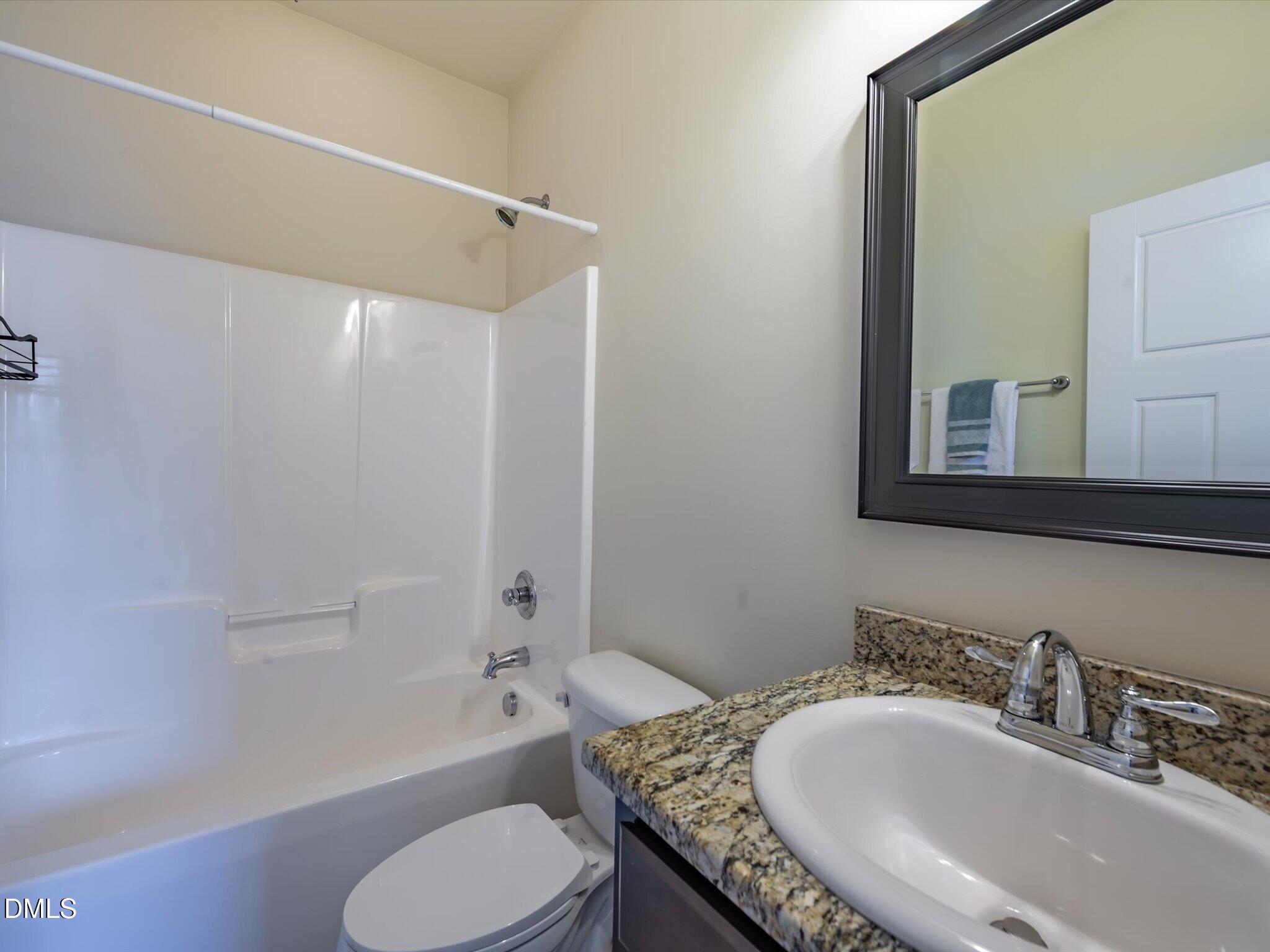 2808 Piedmont River Way Raleigh, NC 27606 - Photo 26 of 28 a bathroom with a granite countertop tub sink toilet and mirror