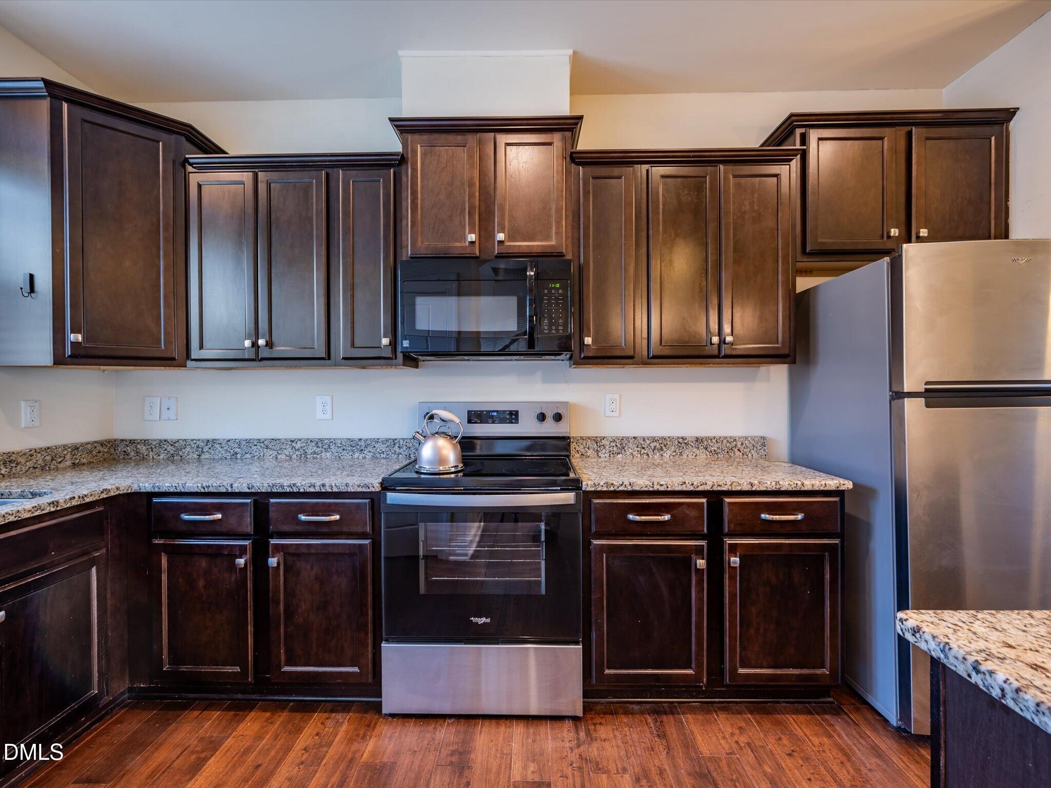 2808 Piedmont River Way Raleigh, NC 27606 - Photo 6 of 28 a kitchen with granite countertop a stove top oven and cabinets