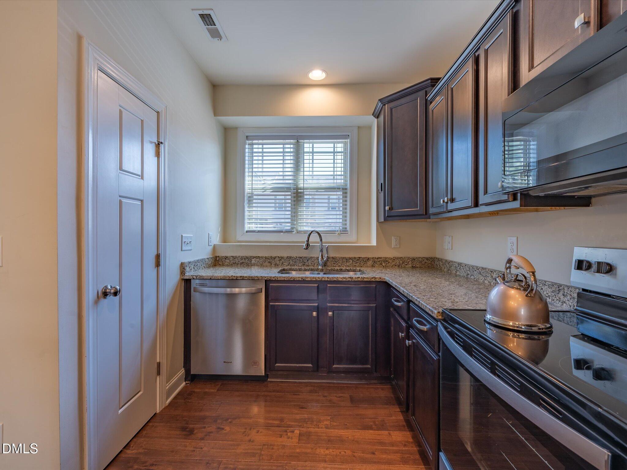 2808 Piedmont River Way Raleigh, NC 27606 - Photo 7 of 28 a kitchen with stainless steel appliances granite countertop a sink stove and refrigerator