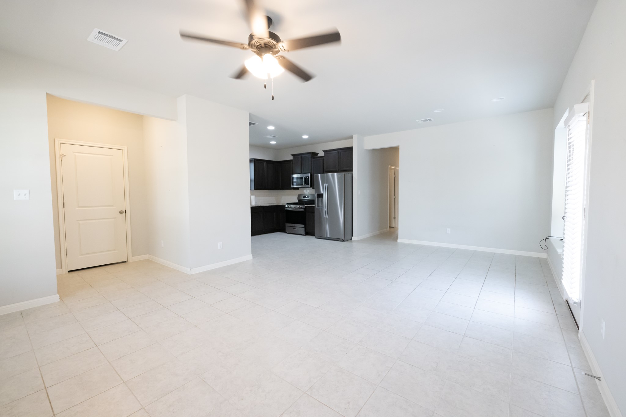 2809 Seneca Path, Unit 30 Leander, TX 78641 - Photo 10 of 30 an empty room with chandelier fan and windows