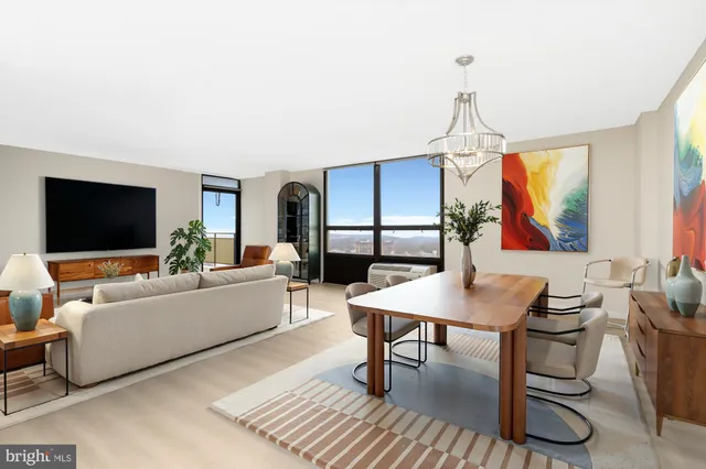 a living room with furniture a flat screen tv and a dining table