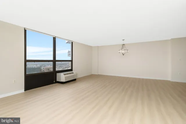 a view of empty room with wooden floor and ceiling fan