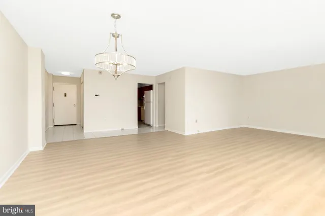 a view of a livingroom with wooden floor and a kitchen space