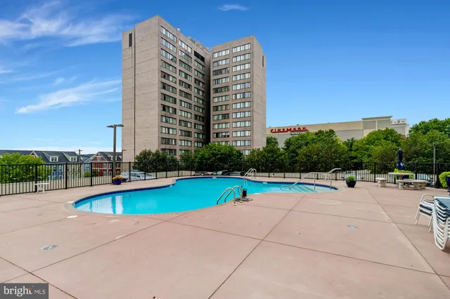 a view of swimming pool with outdoor seating and house in the background
