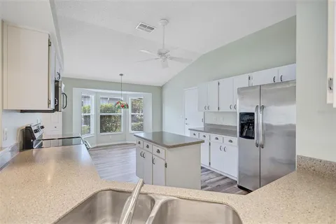 a kitchen with granite countertop a sink stove and refrigerator