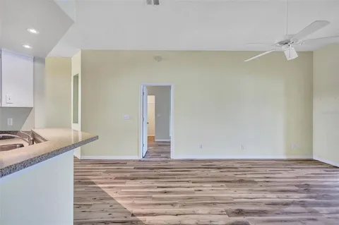 a view of a room with wooden floor and fan