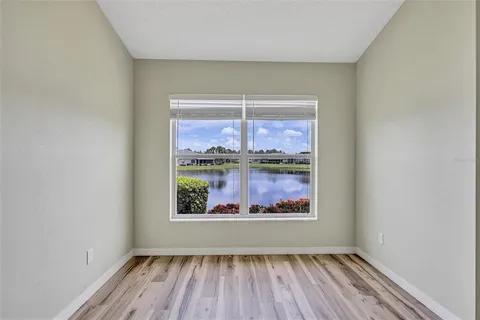 a view of a hallway with wooden floor and a window