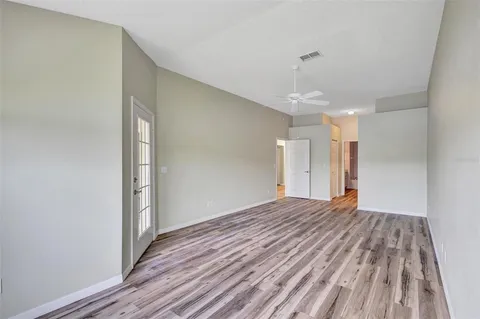 a view of empty room with wooden floor