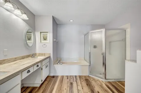 a bathroom with a granite countertop sink a mirror and a bathtub
