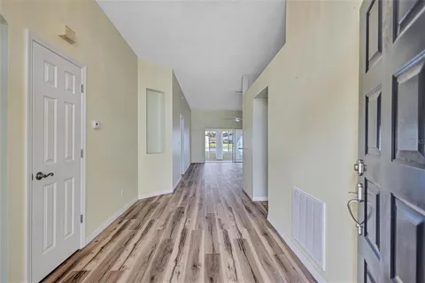 a view of a hallway with wooden floor and staircase