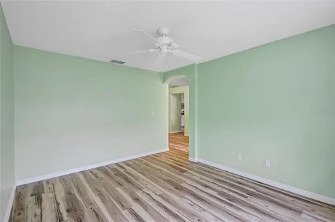 a view of a room with wooden floor and a ceiling fan
