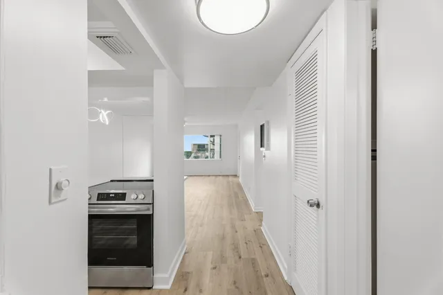 a view of a hallway with wooden floor and staircase