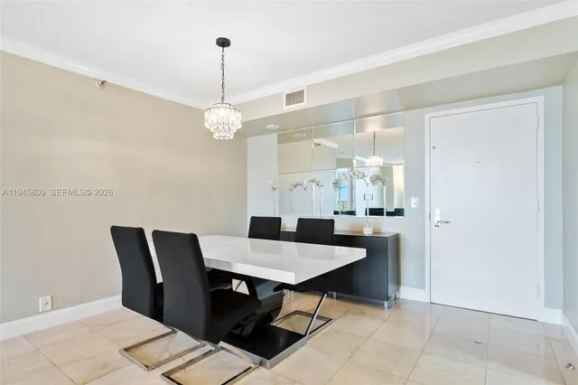 a view of a dining room and livingroom with furniture wooden floor a chandelier