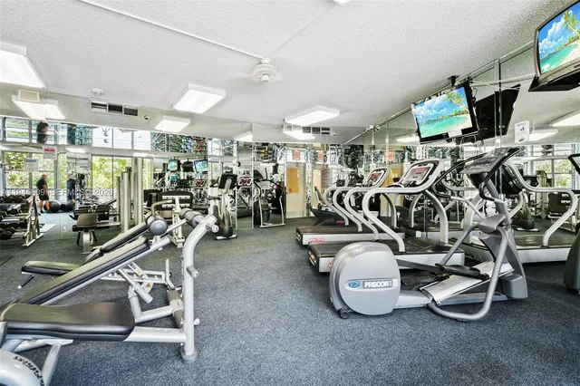 a view of a swimming pool with a bench and trees in the background