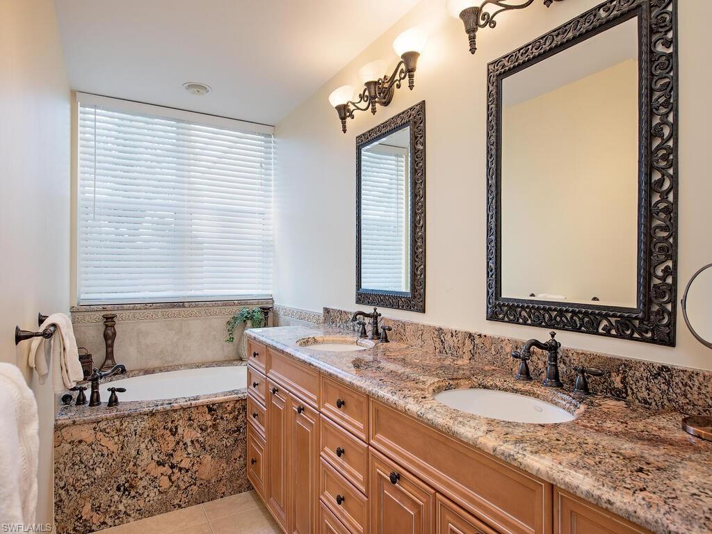 6537 Marissa Loop, Unit 10 Naples, FL 34108 - Photo 11 of 15 a bathroom with a granite countertop sink and a mirror