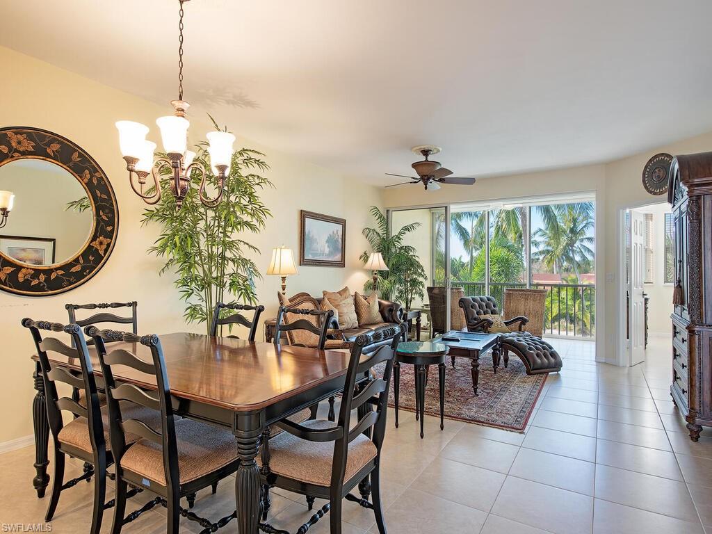 6537 Marissa Loop, Unit 10 Naples, FL 34108 - Photo 6 of 15 a dining room with furniture a chandelier and a floor to ceiling window