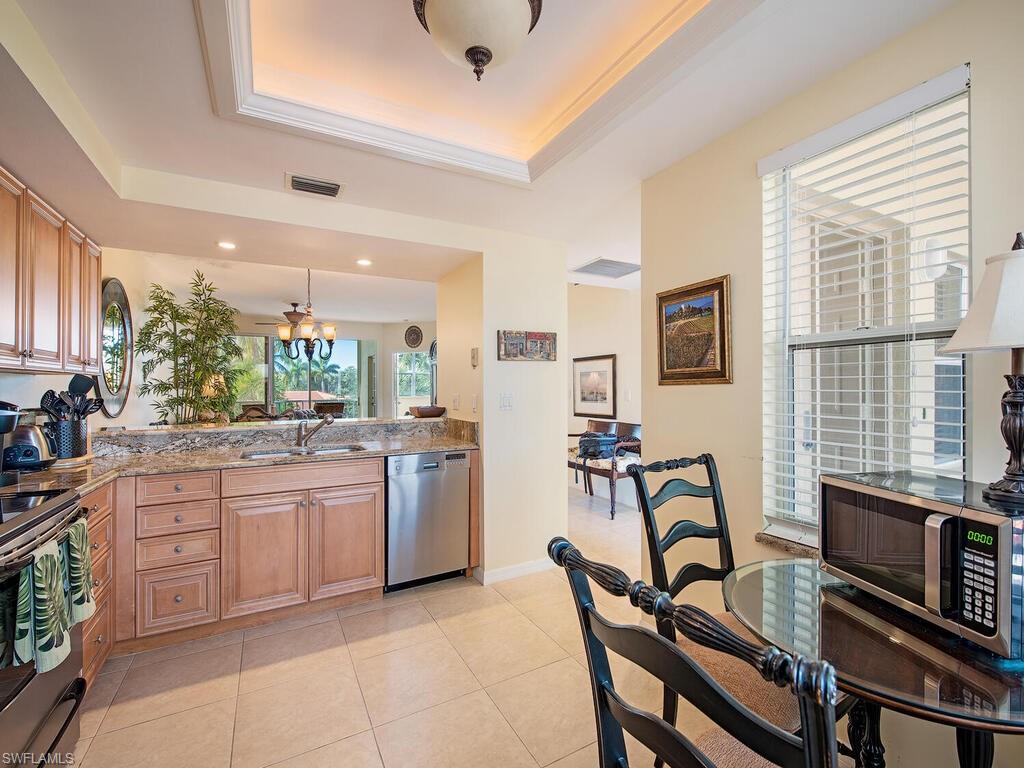 6537 Marissa Loop, Unit 10 Naples, FL 34108 - Photo 8 of 15 a kitchen with sink cabinets and dining table