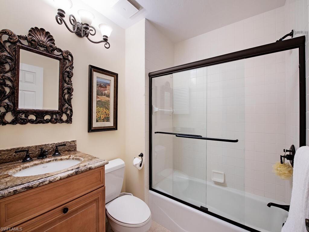 6537 Marissa Loop, Unit 10 Naples, FL 34108 - Photo 9 of 15 a bathroom with a granite countertop sink mirror vanity and toilet