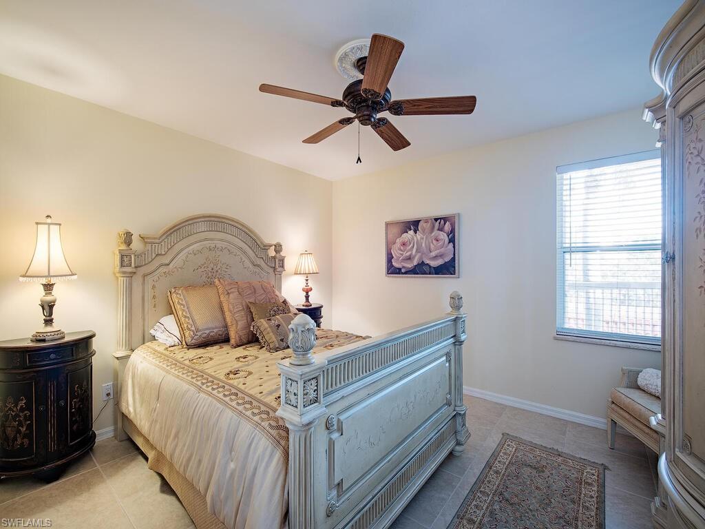 6537 Marissa Loop, Unit 10 Naples, FL 34108 - Photo 10 of 15 a bedroom with a bed and a chandelier