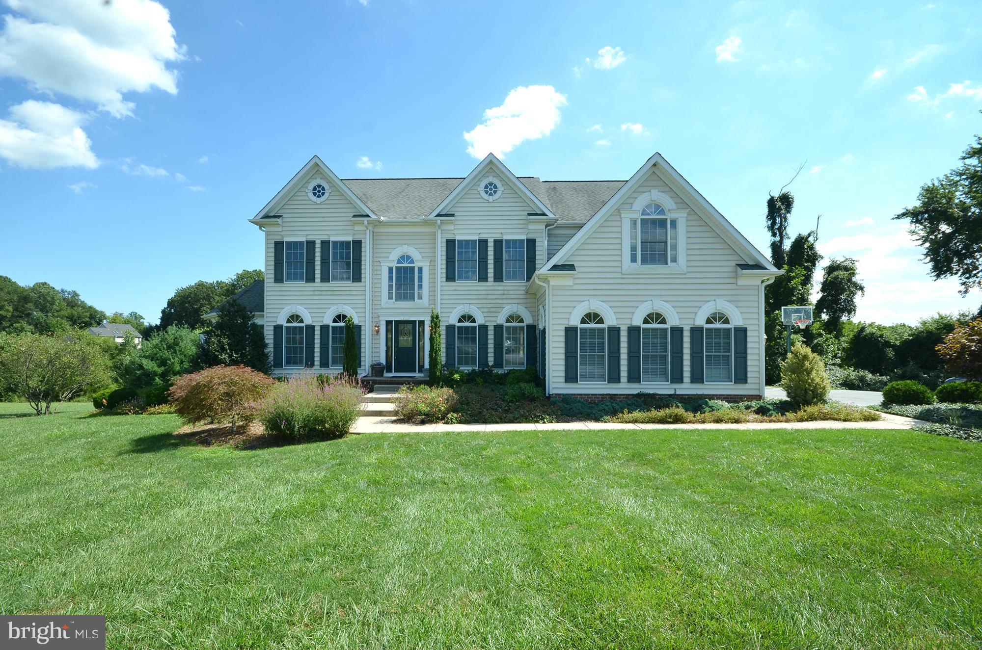 a front view of a house with a garden and plants