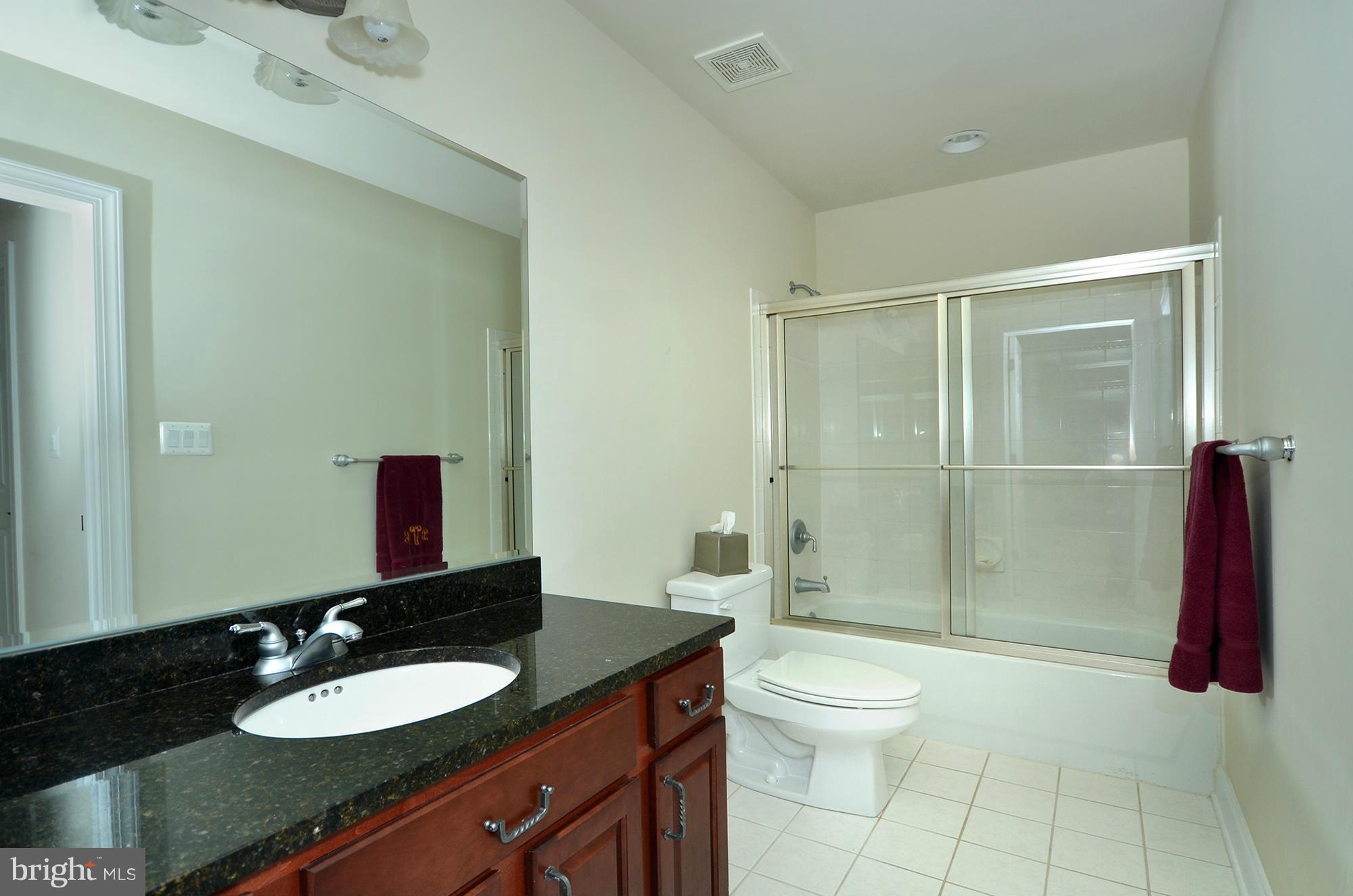 3401 Meredith Ridge Road Phoenix, MD 21131 - Photo 18 of 28 a bathroom with a granite countertop sink toilet a mirror and shower